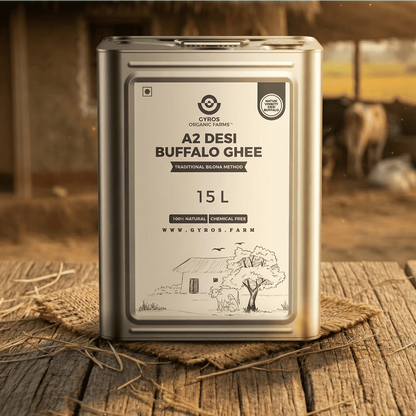 Gyros Organic Farms A2 Desi Buffalo Ghee 15L tin placed on a rustic wooden surface in a village farm setting.