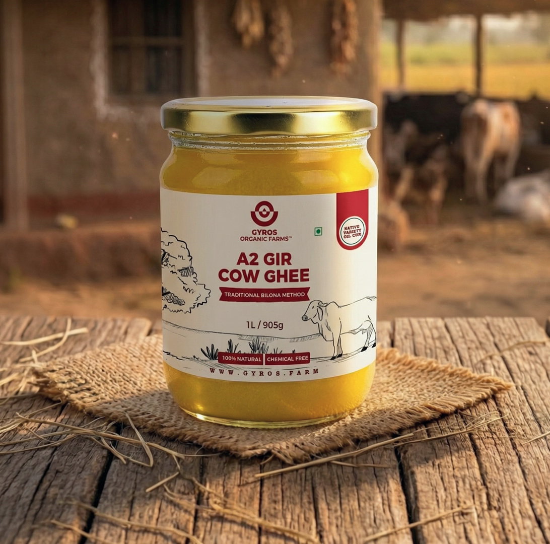A2 Gir cow ghee in a glass jar placed on a rustic wooden table with a village farm background