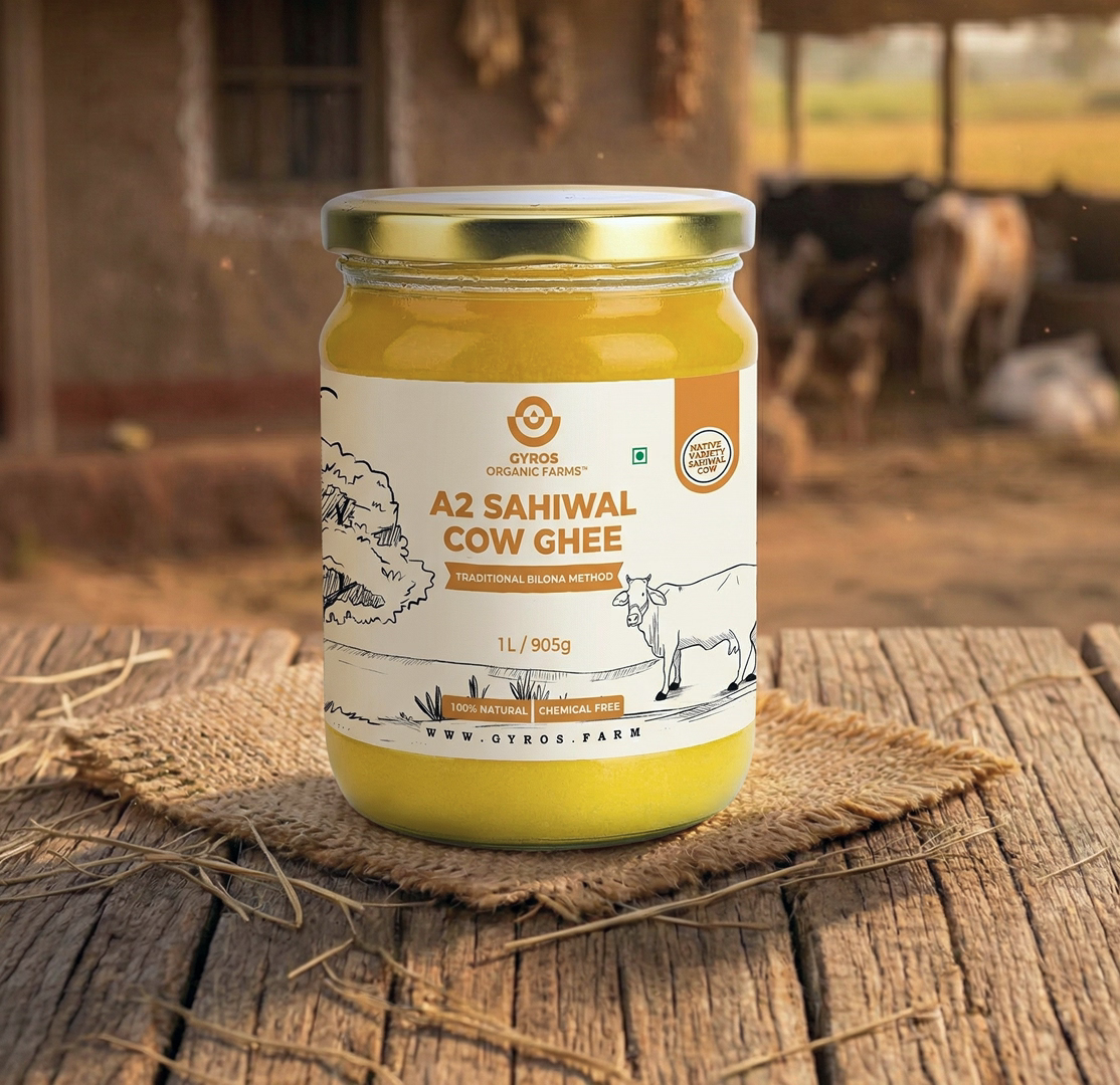 Gyros A2 Sahiwal cow ghee 1L glass jar placed on a wooden surface with warm rural lighting.