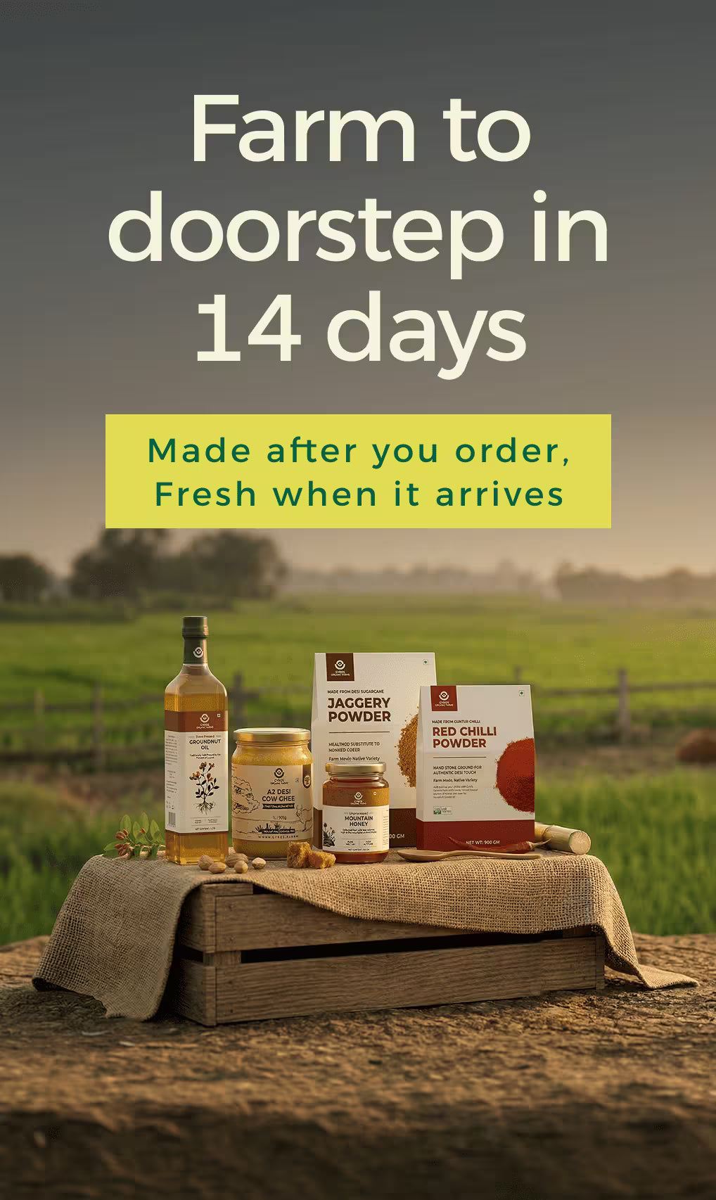 Gyros Organic Farms products including A2 cow ghee, jaggery powder, red chilli powder and groundnut oil displayed on a wooden crate in a farm field with message “Farm to doorstep in 14 days”